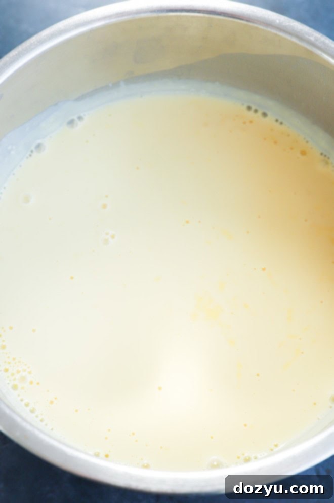 A spoon elegantly scooping a portion of lavender honey ice cream from a bowl, adorned with delicate flowers