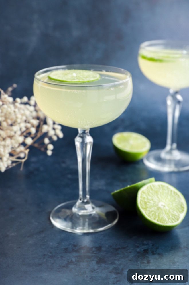 Elderflower cocktail elegantly presented in a coupe glass, garnished with a fresh lime wheel