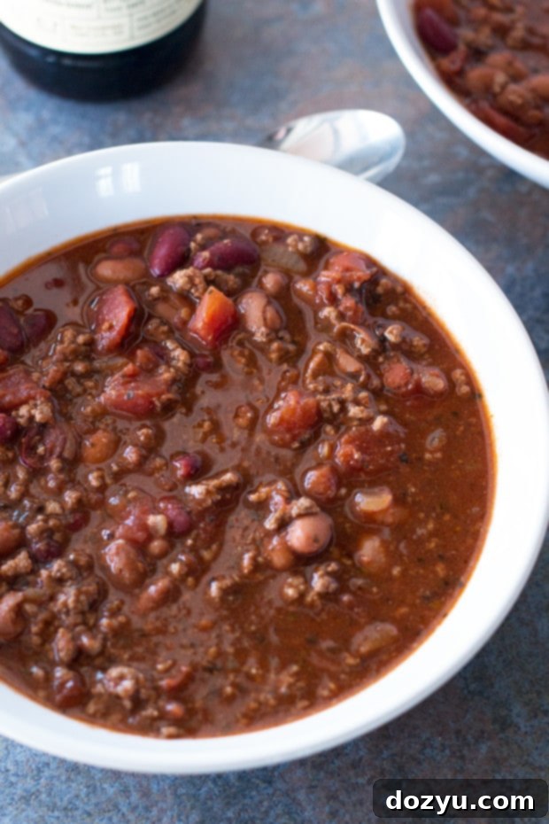 A close-up of the Black Porter Chili simmering in a Dutch oven, showcasing its rich texture and color.
