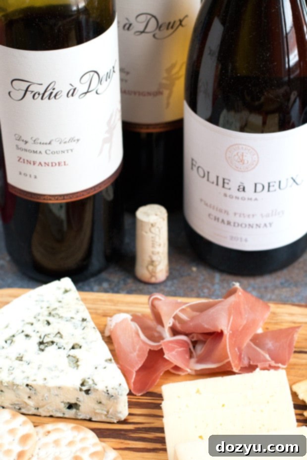 An elaborate Valentine's Day cheese board with wine bottles, showcasing perfect romantic pairings