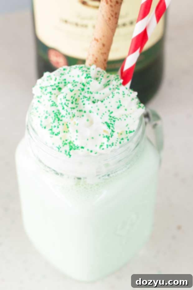 Creamy Boozy Green Shamrock Shake in a tall glass with whipped cream