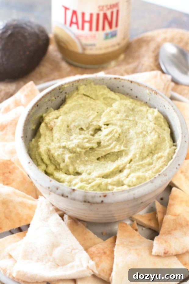 Smooth and creamy Avocado Tahini Dip served with pita bread and fresh vegetables
