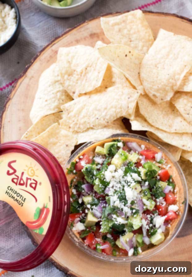 Vibrant South of the Border Hummus with Sabra Hummus topped with fresh ingredients like avocado, tomato, and cilantro, ready to be served.