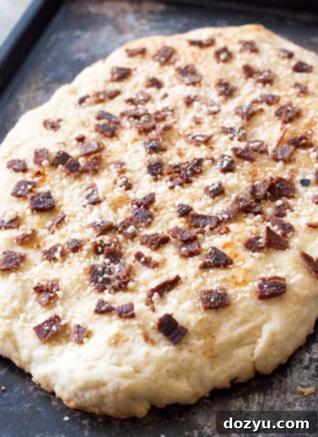 Delicious Bacon Parmesan Quick Bread with a golden crust, sliced and ready to serve on a rustic wooden board.