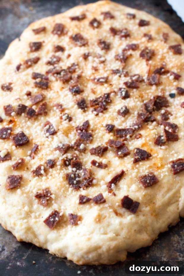 A close-up shot of the crispy, savory Bacon Parmesan Quick Bread, showcasing the parmesan cheese and bits of bacon on top.