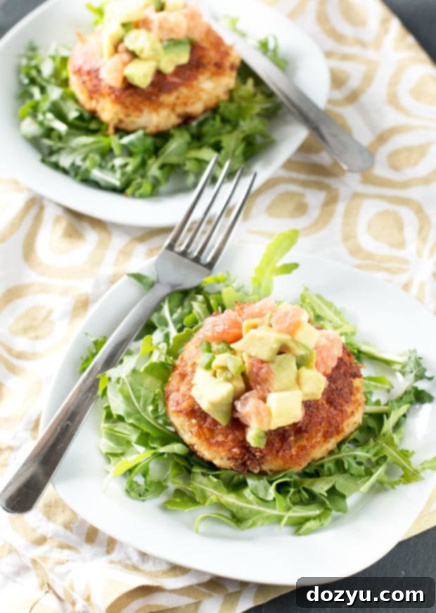 Close-up of a Crispy Crab Cake, highlighting its golden-brown exterior and flaky texture, paired with the colorful Avocado Grapefruit Salsa.