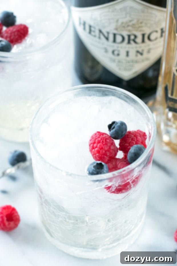 Berry Burst Gin and Tonic 4 Hand holding a glass of Berrylicious Gin & Tonic | cakenknife.com