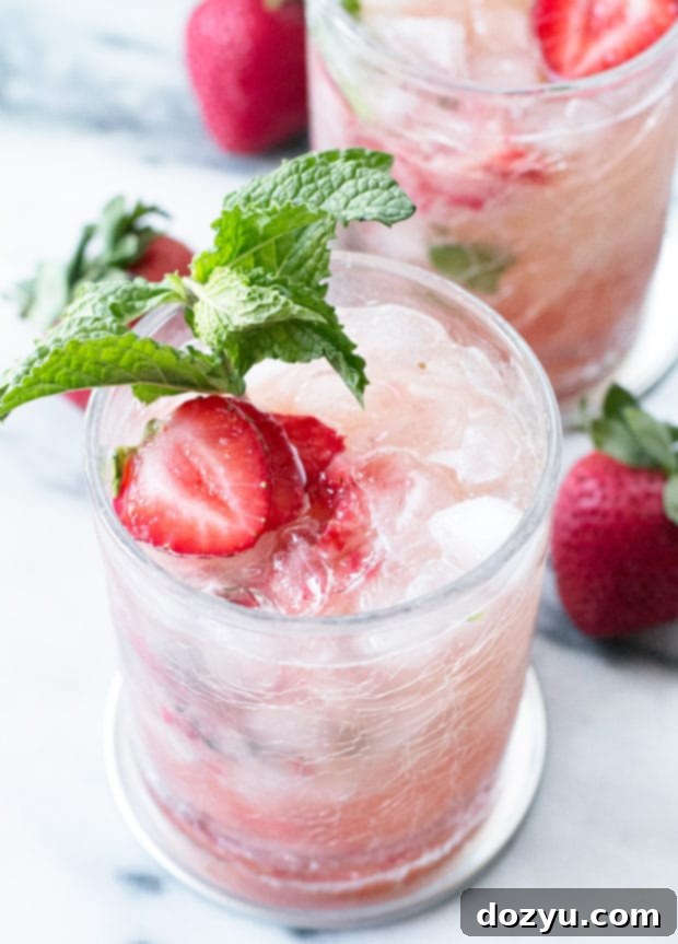 Two Strawberry Mint Juleps garnished with mint and strawberries