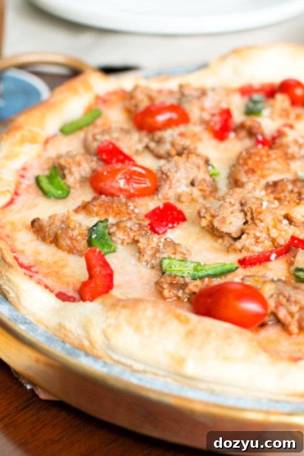 Soapstone pizza pan with copper handle holding a freshly baked pizza