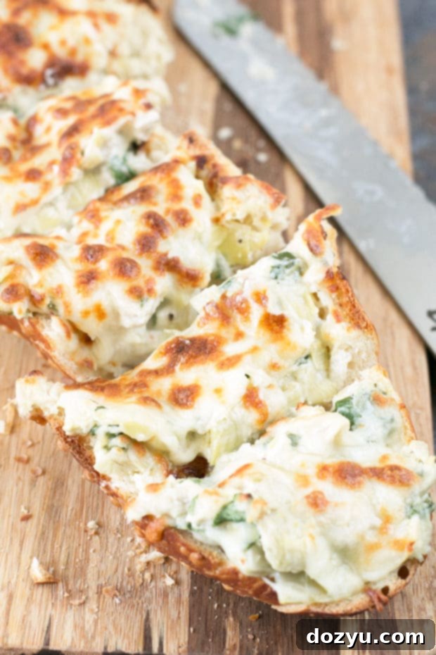Close-up of baked Chicken Spinach Artichoke Dip French Bread with melted cheese
