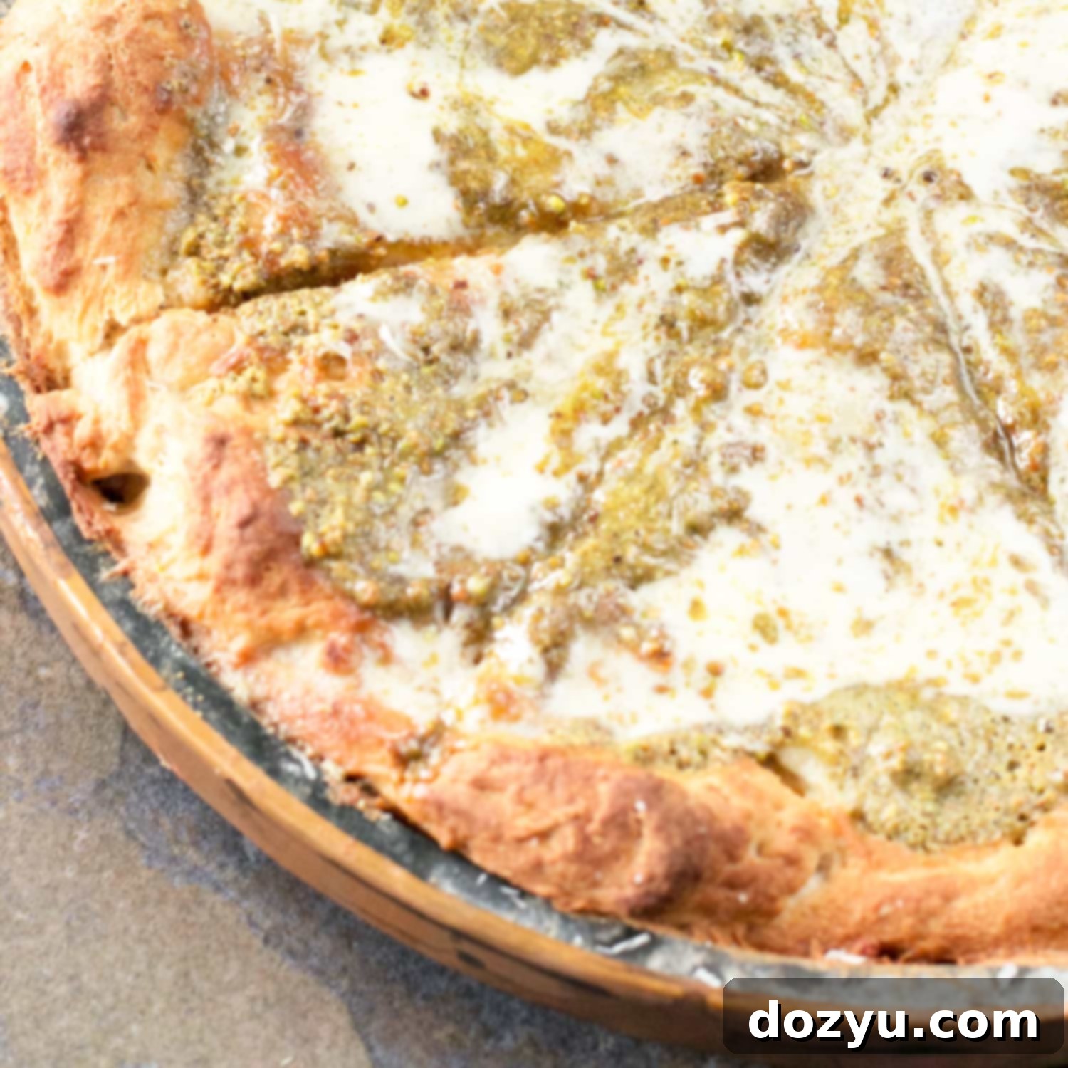 A close-up of the delicious Pistachio Pesto Pizza with Crème Fraîche and Roasted Garlic thumbnail, a gourmet treat.
