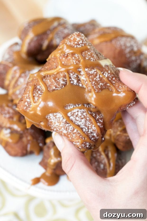 A close-up shot of freshly fried, golden Pumpkin Spice Beignets on a plate