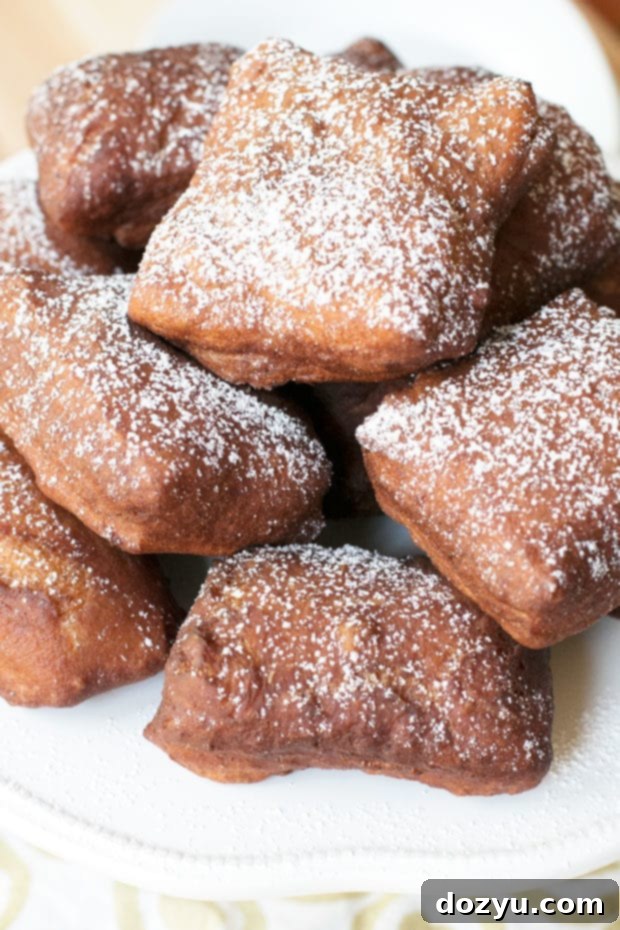 Pumpkin Spice Beignets generously covered in salted caramel sauce on a serving plate