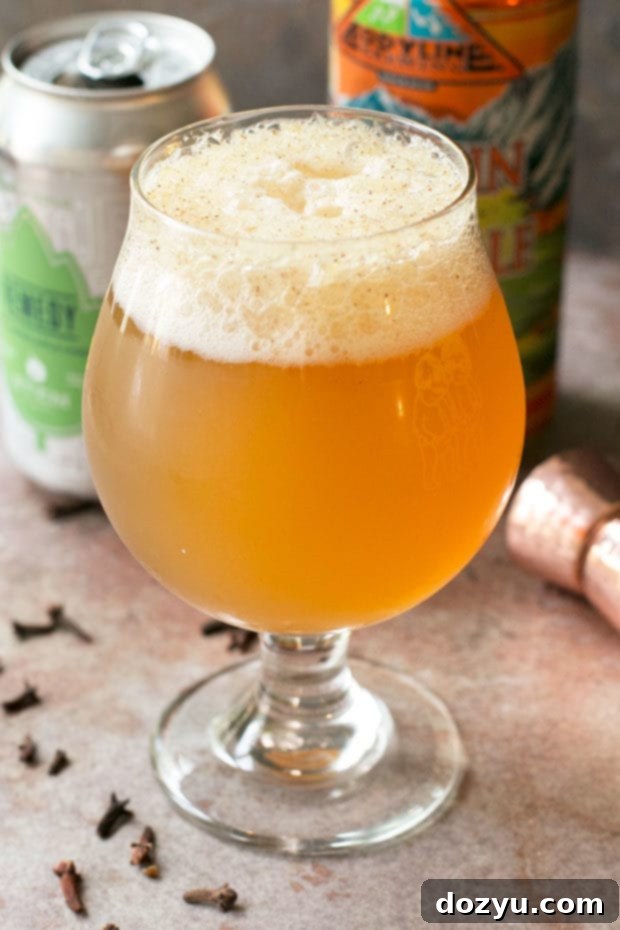 Pumpkin Bang cocktail garnished with a cinnamon stick and orange slice