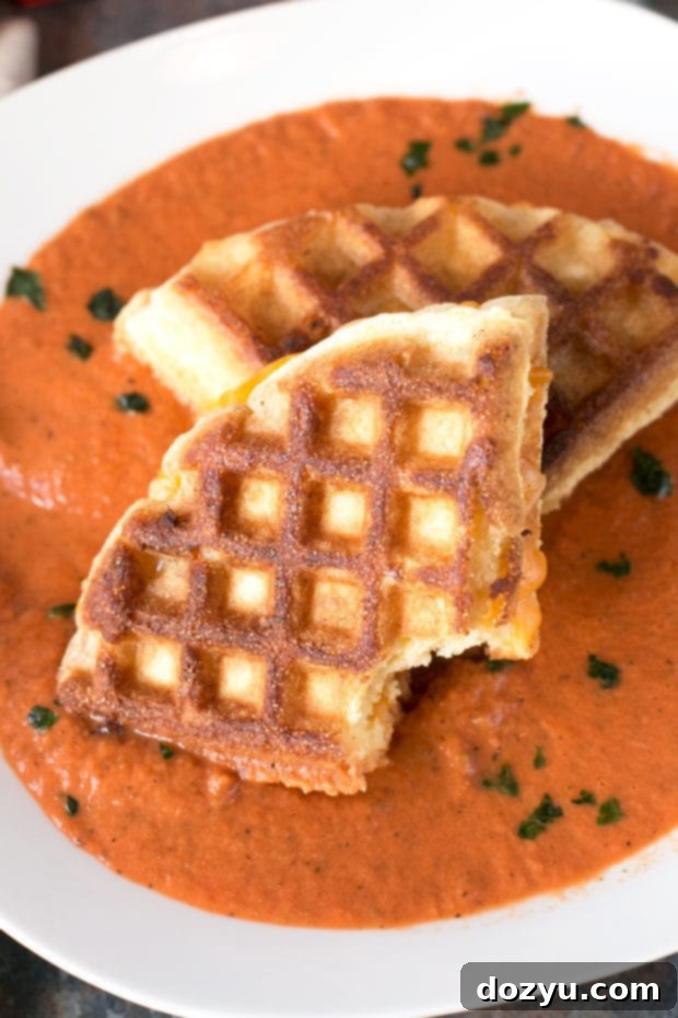 Gooey melted cheese oozing from a crispy Cornbread Waffle Grilled Cheese Sandwich.