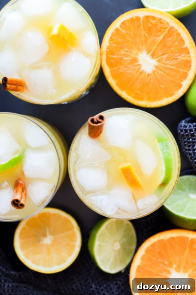 image of big batch cocktail in glasses with citrus fruit halves
