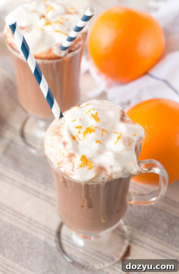 A person enjoying a Hot Orange Mocha Cocktail in a warm, festive indoor setting