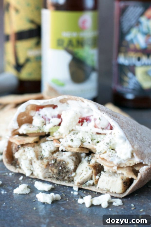Up-close shot of a Crunchy Chicken Gyro Sandwich filling with chicken, feta, cucumbers, and tomatoes