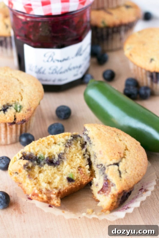 Overhead shot of Blueberry Jalapeño Bacon Cornbread Muffins in a rustic setting, with fresh blueberries and jalapeños