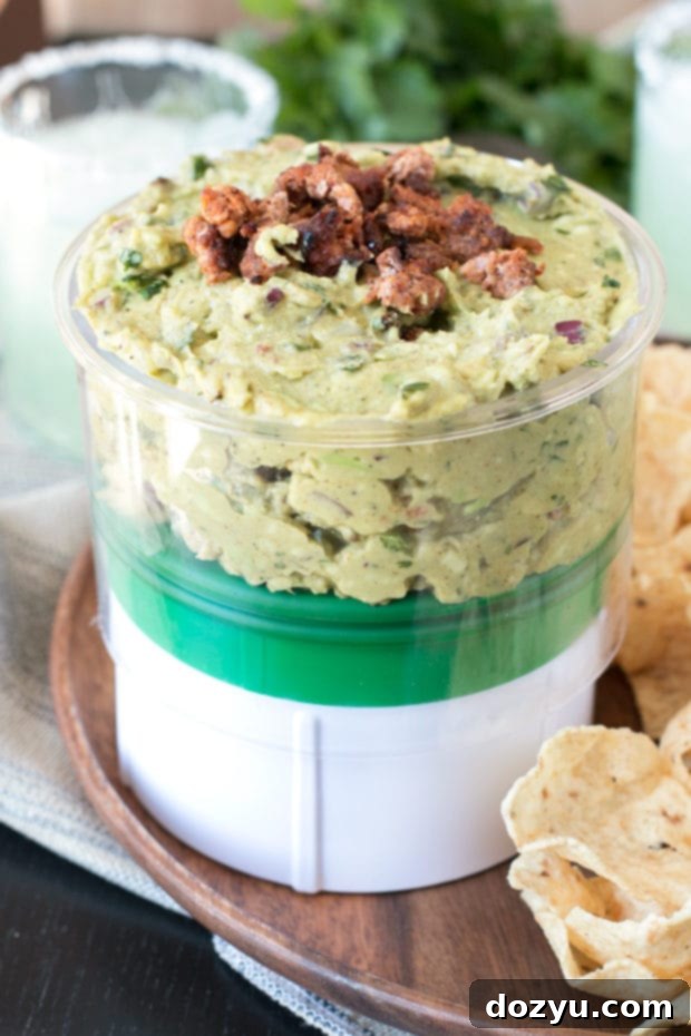 Chipotle Chorizo Guacamole being served from a container, showcasing its vibrant freshness.