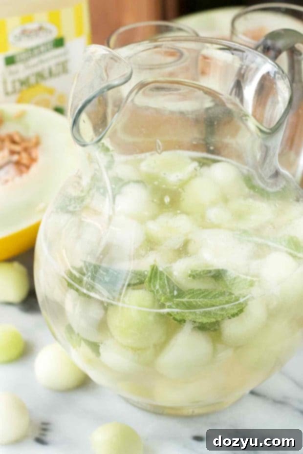 Refreshing Melon Sangria 6 Melon Sangria poured into glasses with melon balls and mint garnish