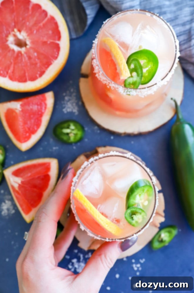 Hand holding a salty dog cocktail in a glass