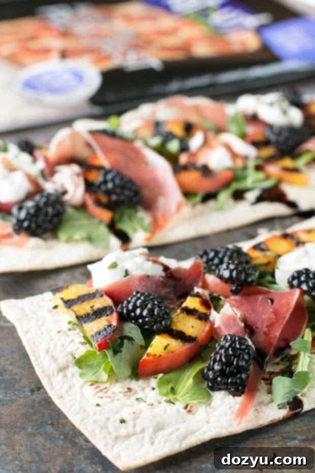 Sliced grilled peach prosciutto flatbread on a wooden board