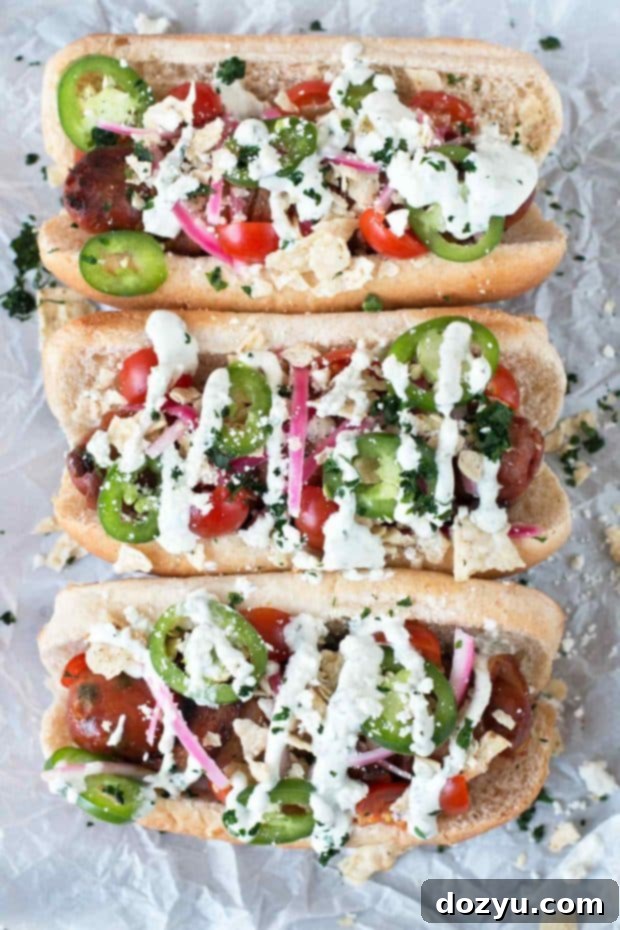 Fiery Bacon Brats Crowned with Zesty Pickled Red Onions 4 Overhead shot of two fully loaded spicy bacon-wrapped bratwursts, showcasing the vibrant homemade pickled red onions and other delicious garnishes.