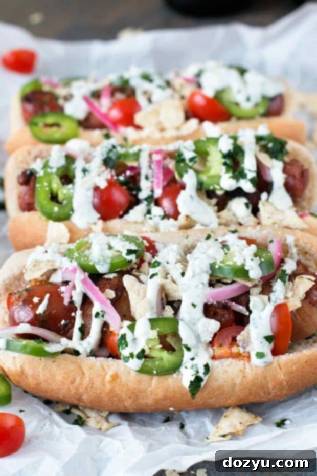 Fiery Bacon Brats Crowned with Zesty Pickled Red Onions 7 Two hands holding a bacon-wrapped bratwurst sandwich, highlighting the generous toppings and deliciousness of this summer grilling recipe.