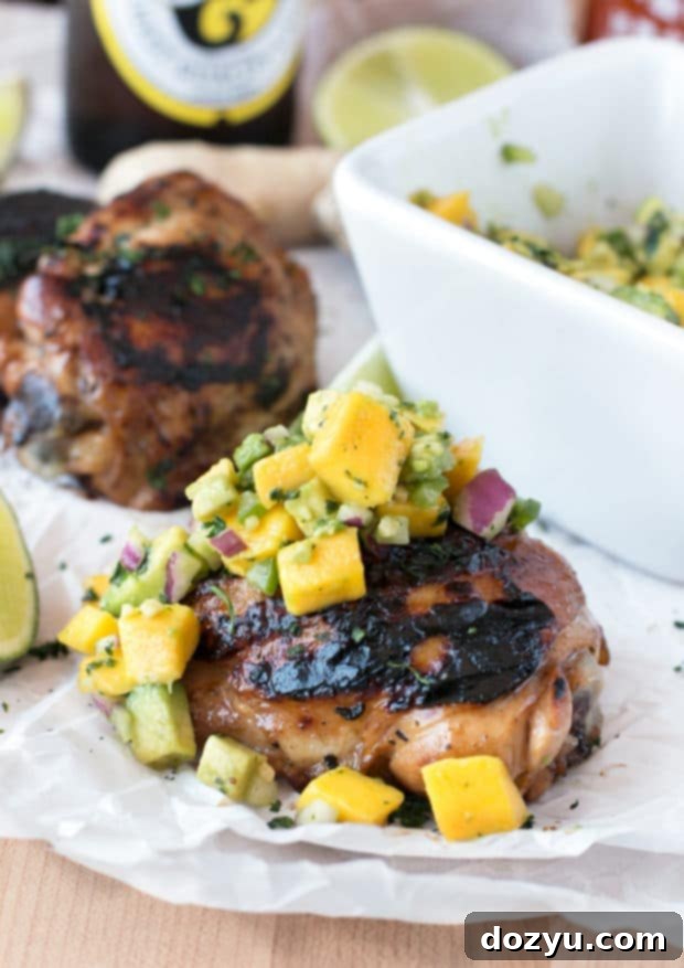 Zesty Ginger-Grilled Chicken Thighs with Creamy Avocado Salsa 4 Overhead view of grilled chicken thighs, golden brown and juicy, presented with a side of freshly prepared avocado salsa. Ideal for versatile meal planning.