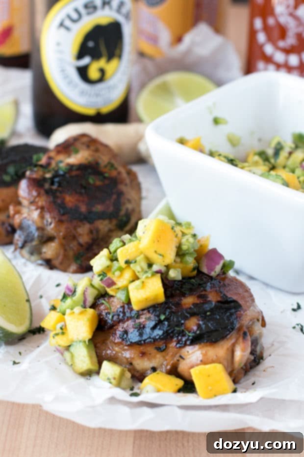 Zesty Ginger-Grilled Chicken Thighs with Creamy Avocado Salsa 6 A close-up of the spicy ginger chicken thighs on the grill, showcasing the crispy skin and delicious char marks, indicating perfect grilling.