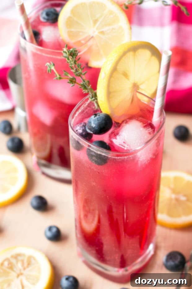 Sparkling Blueberry Thyme Vodka Lemonade being poured, emphasizing its bubbly texture.
