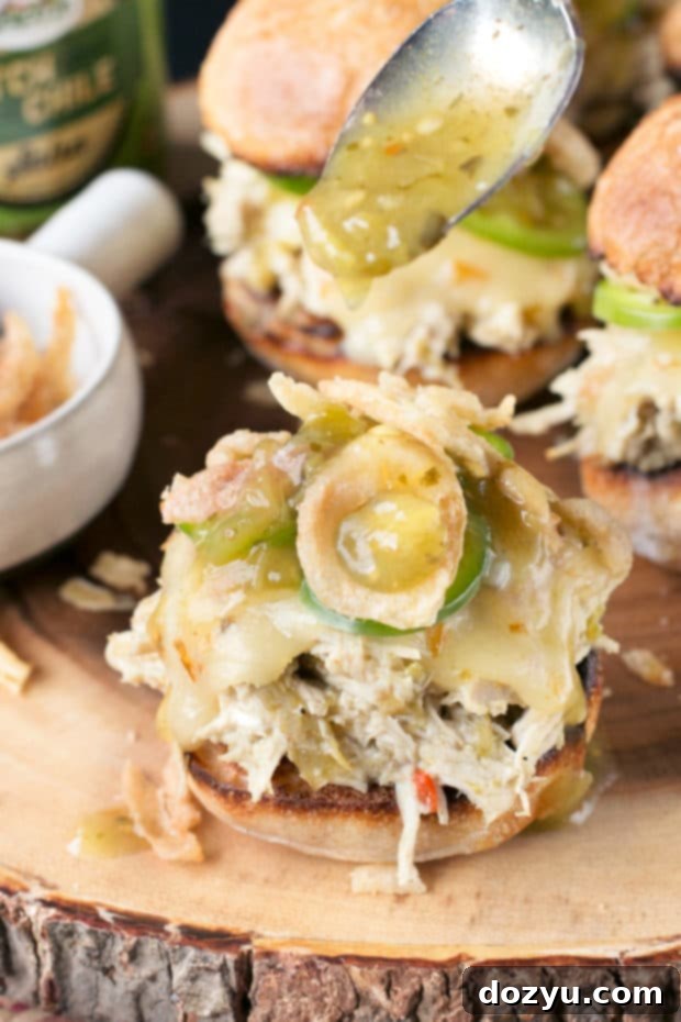 Close-up of a Hatch Green Chile Chicken Slider with melted cheese and fresh toppings.