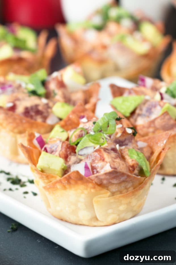 Spicy Tuna Poke Wonton Cups on a serving platter with fresh herbs