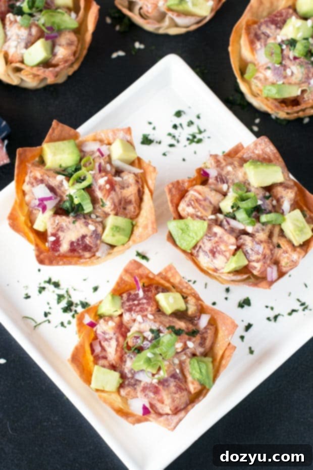 Platter of Spicy Tuna Poke Wonton Cups, garnished with cilantro and sesame seeds