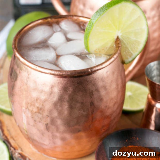 Spicy Mezcal Mule thumbnail image: A copper mug filled with ice, mezcal mule, and lime garnish, ready to drink.