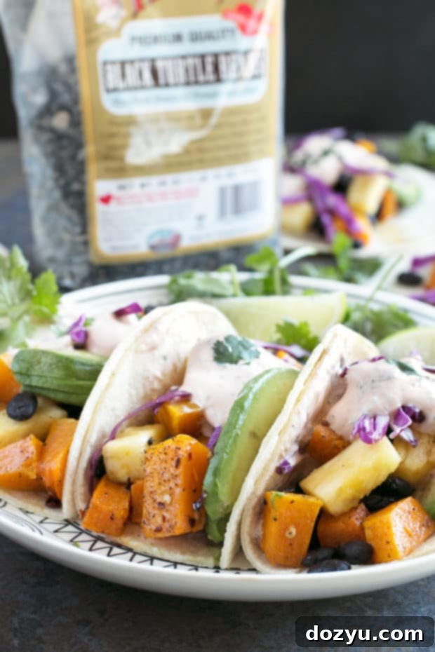 Another view of the Roasted Butternut Squash Black Bean Tacos, arranged on a rustic wooden surface with fresh ingredients. #vegetarian #healthy #tacotuesday #sponsored
