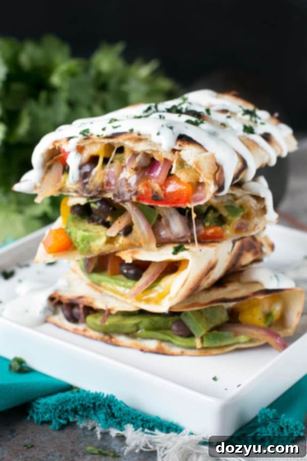 Creamy Veggie Avocado Quesadilla with Zesty Cilantro Crema 5 A beautifully assembled Veggie Avocado Quesadilla, featuring vibrant vegetables and melted cheese within a golden-brown tortilla.