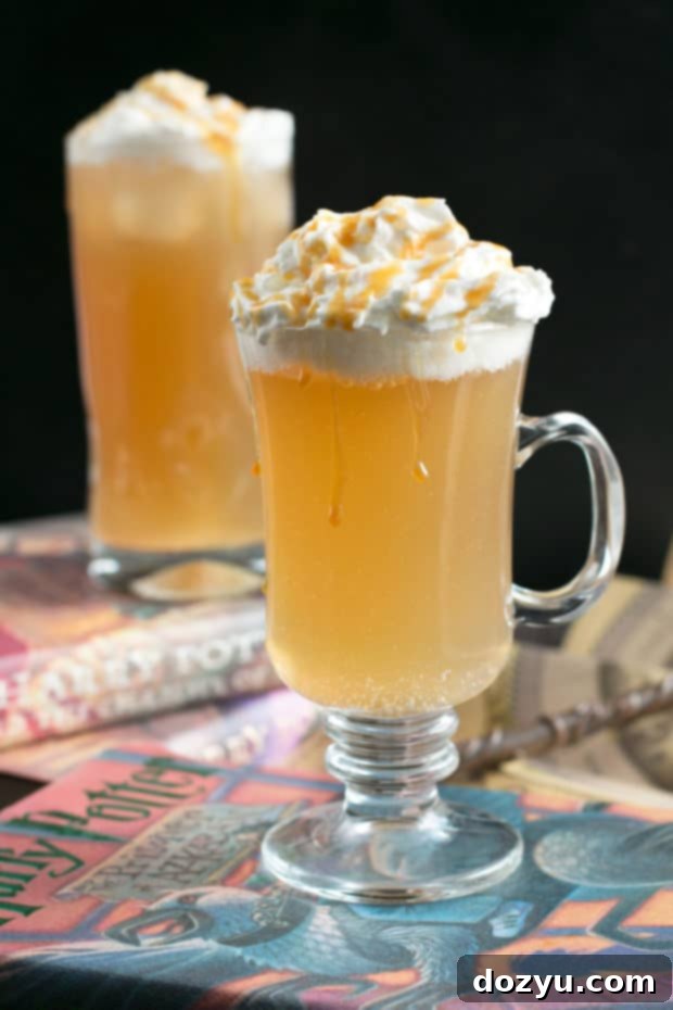 Butterbeer Cocktail Double the Magic 2 A frothy, golden Butterbeer Cocktail in a clear glass, garnished with whipped cream and a butterscotch drizzle, ready to be enjoyed.