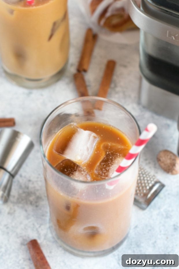 A glass of Eggnog Cold Brew Coffee Cocktail garnished with cinnamon stick and nutmeg.