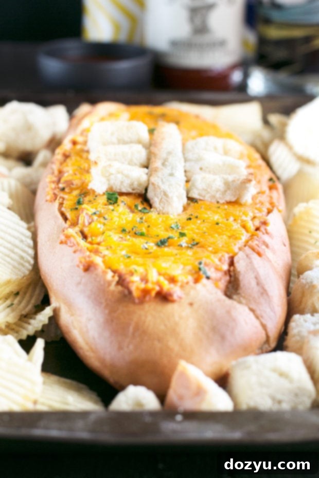 Close-up of Cheesy Pulled Pork BBQ Bread Dip, highlighting the rich texture and football laces detail.