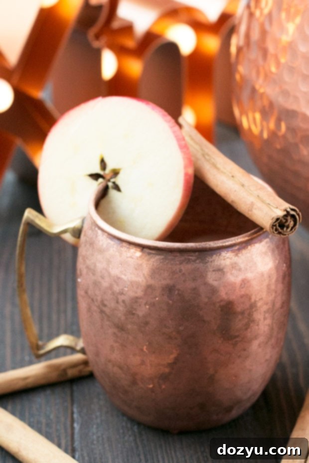 Variety of ingredients for Gingerbread Bourbon Punch, including bourbon, ginger beer, apples, and cinnamon sticks.