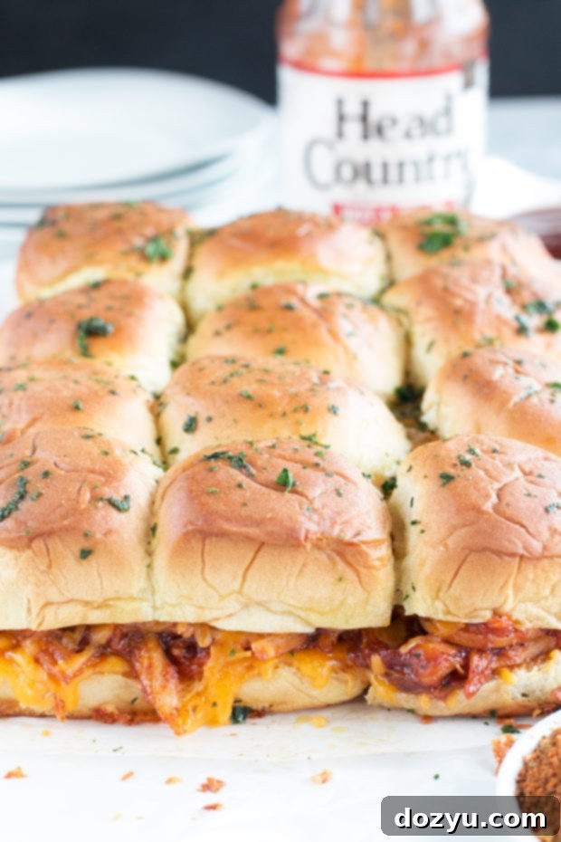 Overhead shot of freshly baked Cheesy BBQ Chicken Pull Apart Sliders in a baking dish