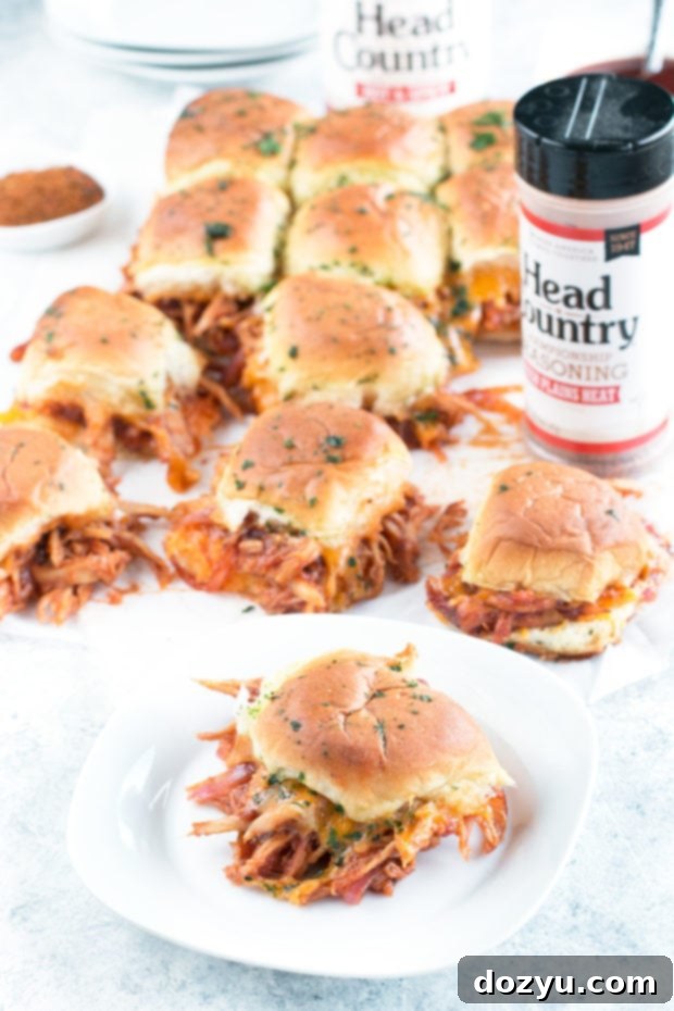 Freshly baked Cheesy BBQ Chicken Pull Apart Sliders with melted cheese and herbs