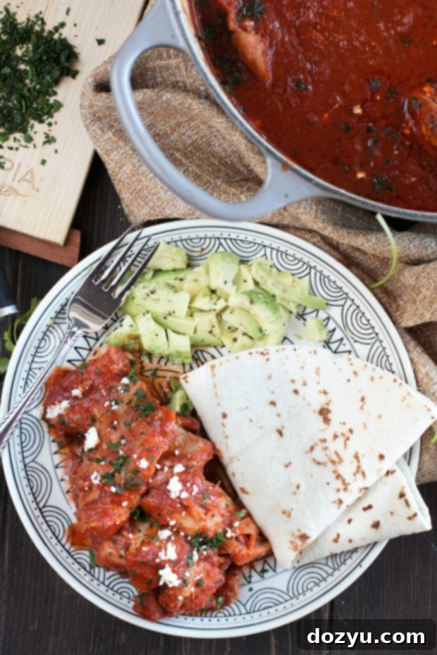 Saucy Chipotle Braised Chicken Thighs simmering in a deep pot.