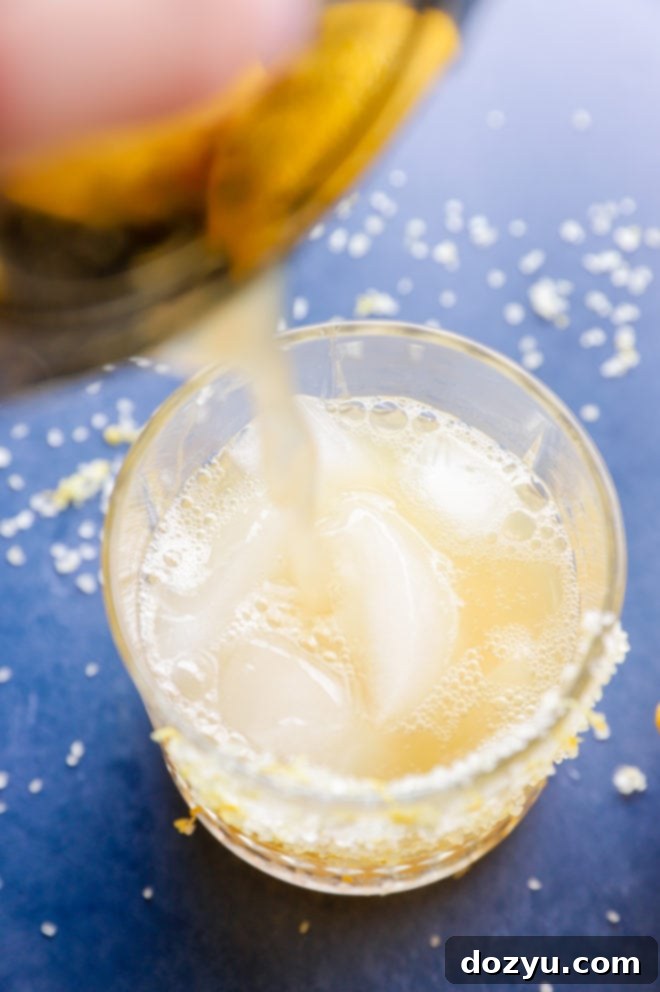 Pouring margarita into a glass of ice image
