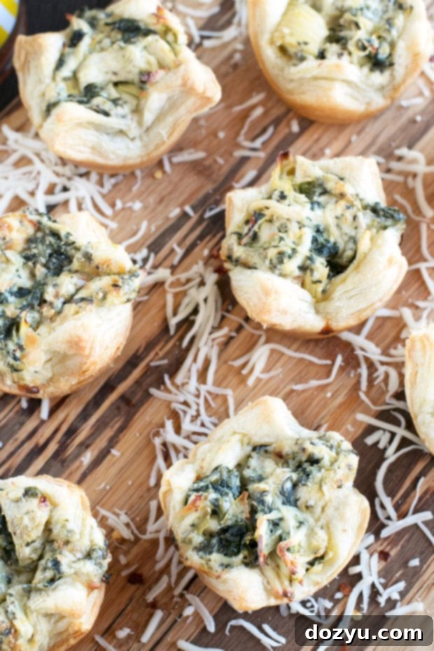 A top-down view of Chicken Spinach Artichoke Dip Puffs arranged neatly, showcasing their golden crust and creamy filling.