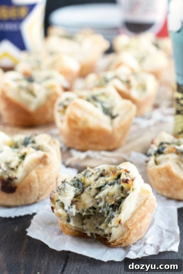 Several Chicken Spinach Artichoke Dip Puffs cooling on a wire rack, showcasing their golden-brown edges.