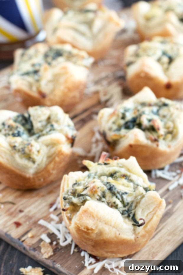 A close-up shot of the flaky pastry of a Chicken Spinach Artichoke Dip Puff, with the creamy filling visible.