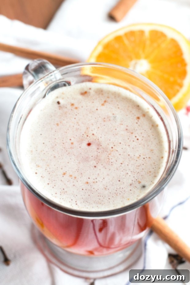 Steaming mug of Mulled Ale garnished with an orange slice